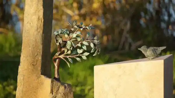 Grabstein mit Bronzebaum und Vogel